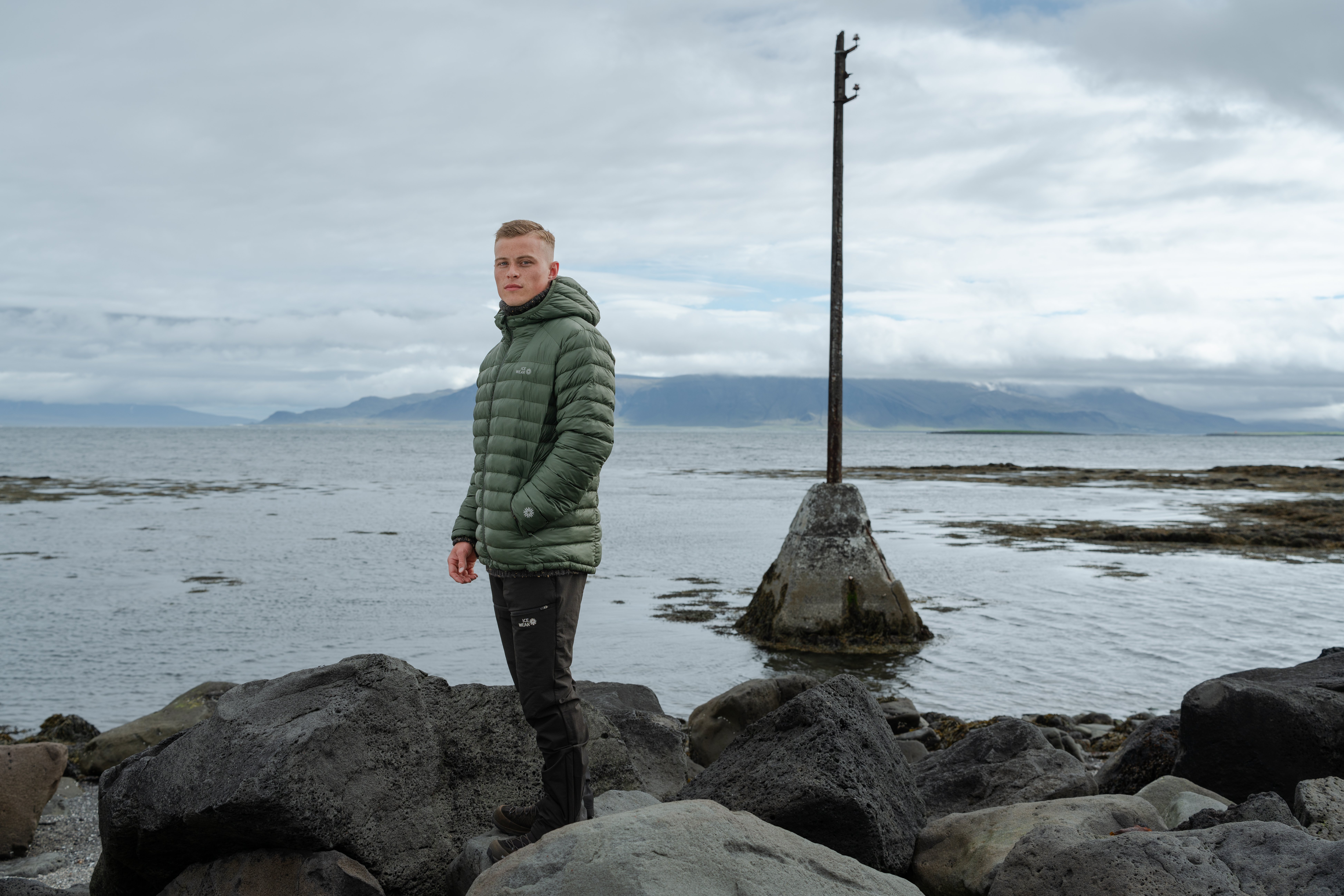 man-green-downjacket-beach.jpeg