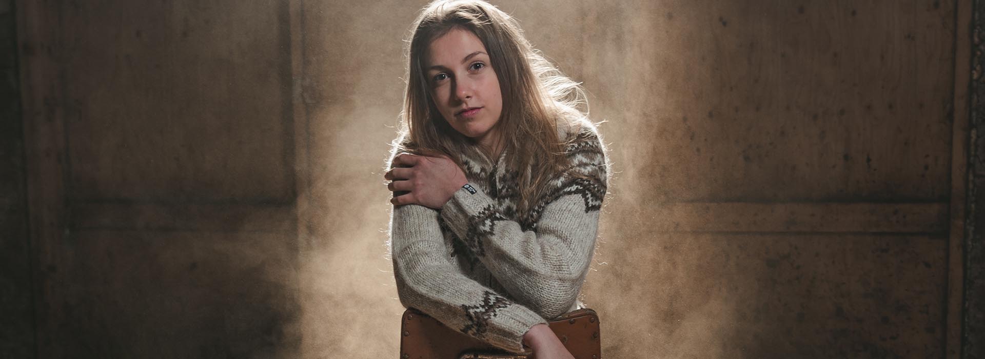 young woman sitting dressed in wool sweater